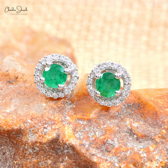 Elevate your elegance with these emerald and diamond halo stud earrings.