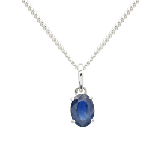 Oval cut 7x5mm blue sapphire solitaire pendant in 14k white gold by Chordia Jewels.