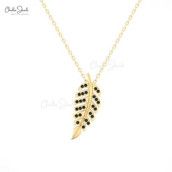 Gold leaf-shaped pendant with black stones on a gold chain for women
